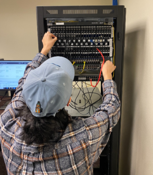 A computer technology student works on a computer system