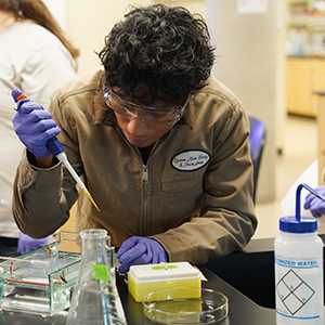 A WVC biology student uses a pipette to load gel during a gel electrophoresis lab.